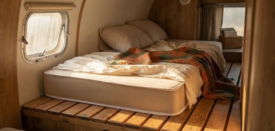 Foam cot mattress unrolled across a camping cot deck